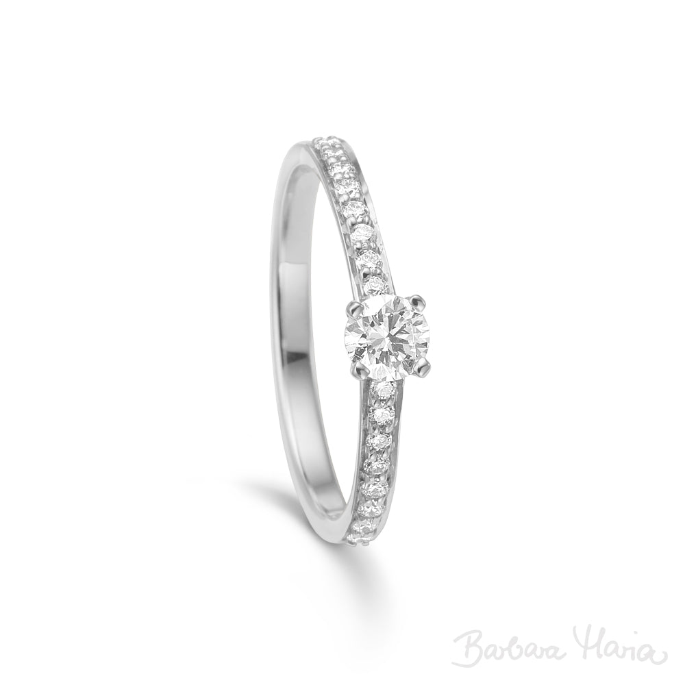 Embrace ringen er en klassisk forlovelsesring eller vielsesring fremstillet i 14kt blankt og rhodineret hvidguld med 0,41ct TW/VS brillanter. Ringen har en smuk 0,25ct TW/VS brillant i en forhøjet fatning. Derudover er der indfattet 0,16ct TW/VS brillante