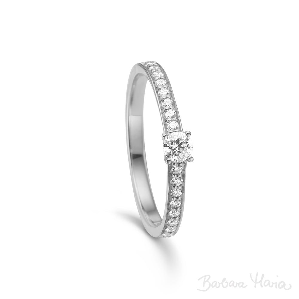 Embrace ringen er en klassisk forlovelsesring eller vielsesring fremstillet i 14kt blankt og rhodineret hvidguld med 0,31ct TW/VS brillanter. Ringen har en smuk 0,15ct TW/VS brillant i en forhøjet fatning. Derudover er der indfattet 0,16ct TW/VS brillante