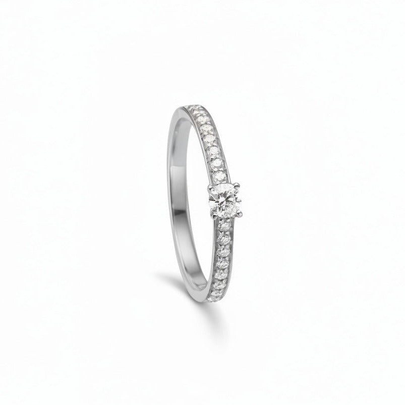 Embrace ringen er en klassisk forlovelsesring eller vielsesring fremstillet i 14kt blankt og rhodineret hvidguld med 0,31ct TW/VS brillanter. Ringen har en smuk 0,15ct TW/VS brillant i en forhøjet fatning. Derudover er der indfattet 0,16ct TW/VS brillante