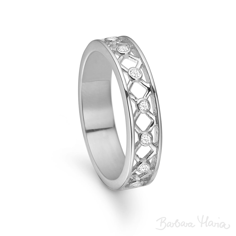 Seven Kisses er en moderne og elegant ring fremstillet i 14kt blankt hvidguld. Ringen har 7 X'er i et åbent fletmønster på oversiden af ringen, som symboliserer 7 kys - et for hver dag i ugen. I hvert X er der i centrum indfattet en 0,01ct TW/VS brillant